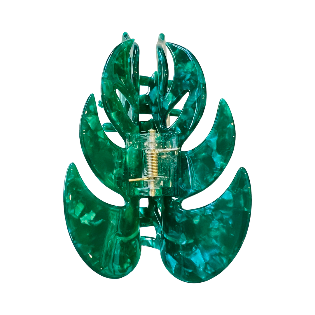 A green, monstera leaf-shaped hair clip made of acetate.