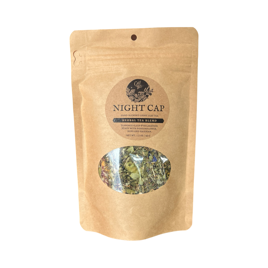 2 oz kraft pouch of Night Cap tea with a branded label and a clear window that displays the dried herbs and flowers that makes the tea.