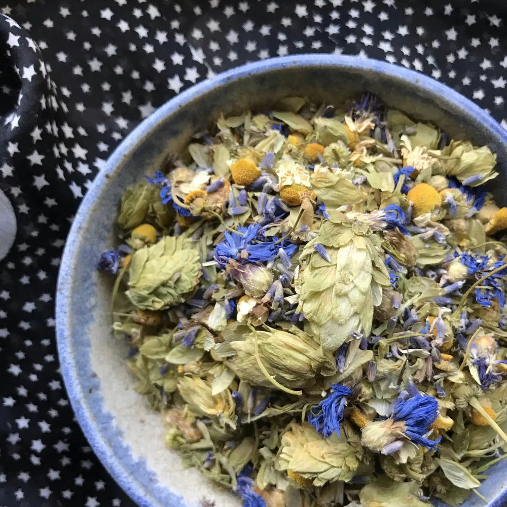 bowl of herbal tea on a table with a black tablecloth featuring white stars