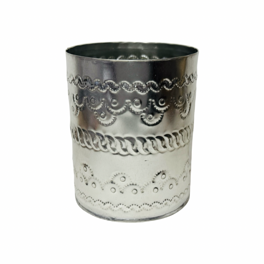 Decorative silver tumbler with intricate patterns on a white background