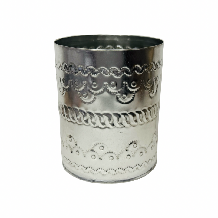 Decorative silver tumbler with intricate patterns on a white background