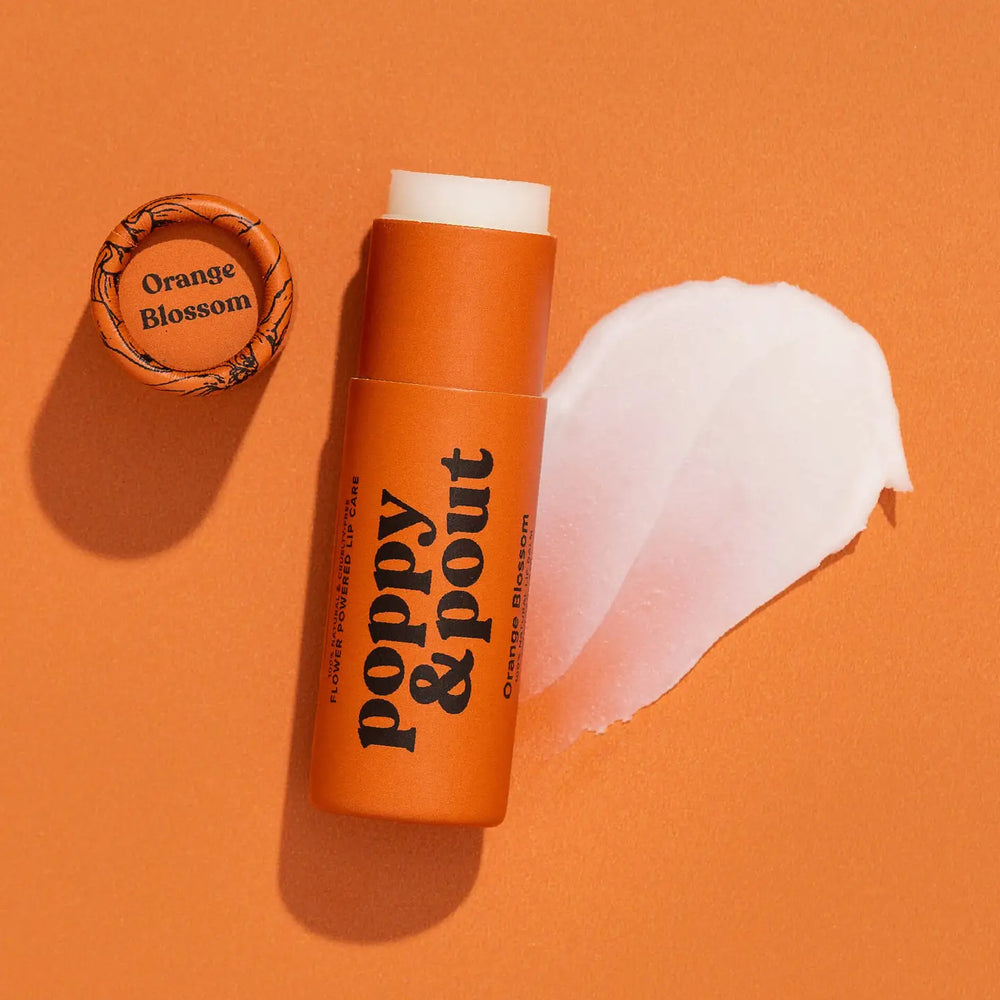 Eco-friendly lip balm tube labeled “poppy & pout” with matching cap and a swatch of balm beside it.
