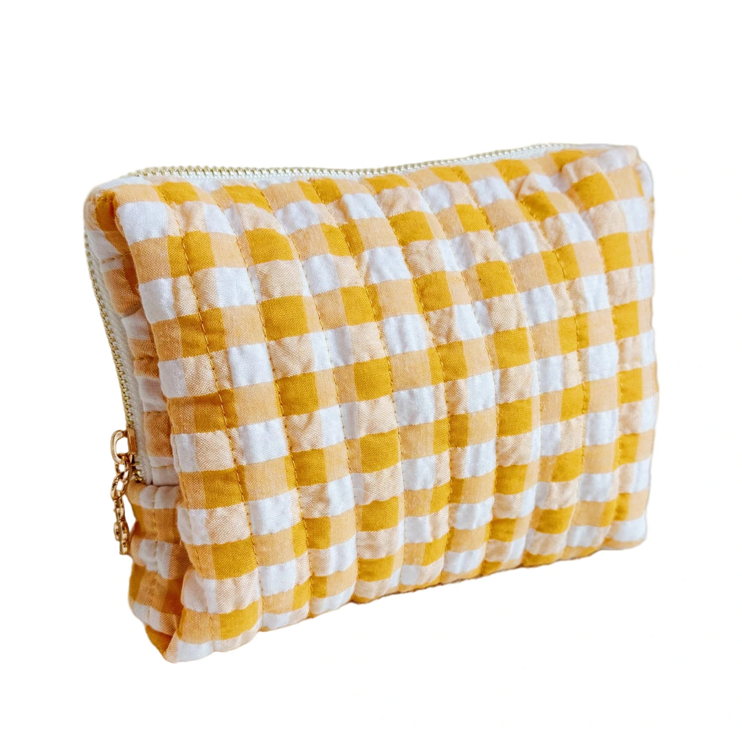 Quilted orange-and-white gingham cosmetic pouch with a gold zipper.