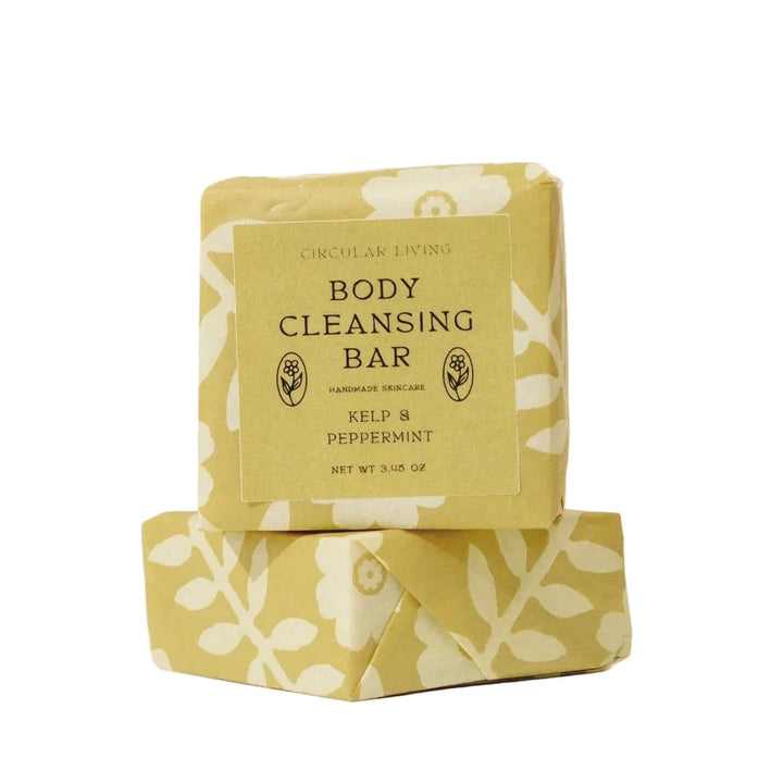 Two wrapped Peppermint and Kelp Body Cleansing Bars by Circular Living stacked on top of each other, wrapped in golden floral paper with a label reading Body Cleansing Bar, Kelp and Peppermint.