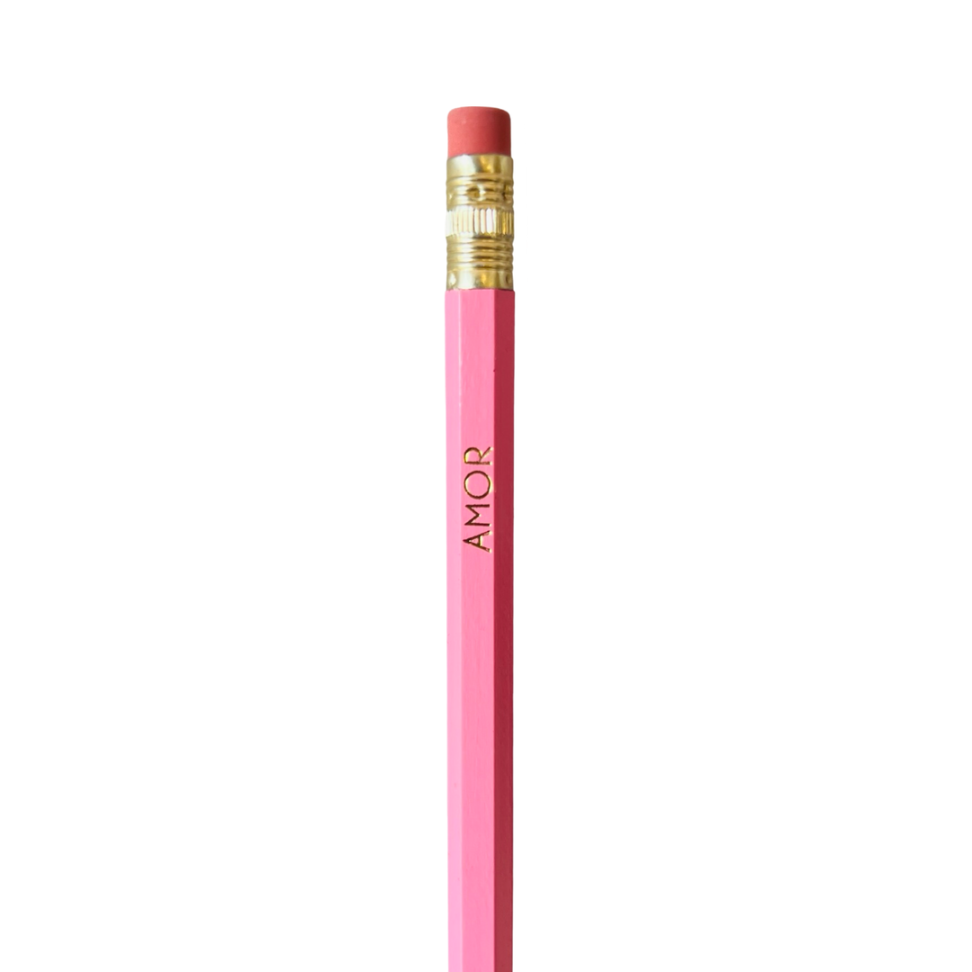 A pink pencil with 'AMOR' printed in gold lettering on the side, with an eraser and sharpener at the top.
