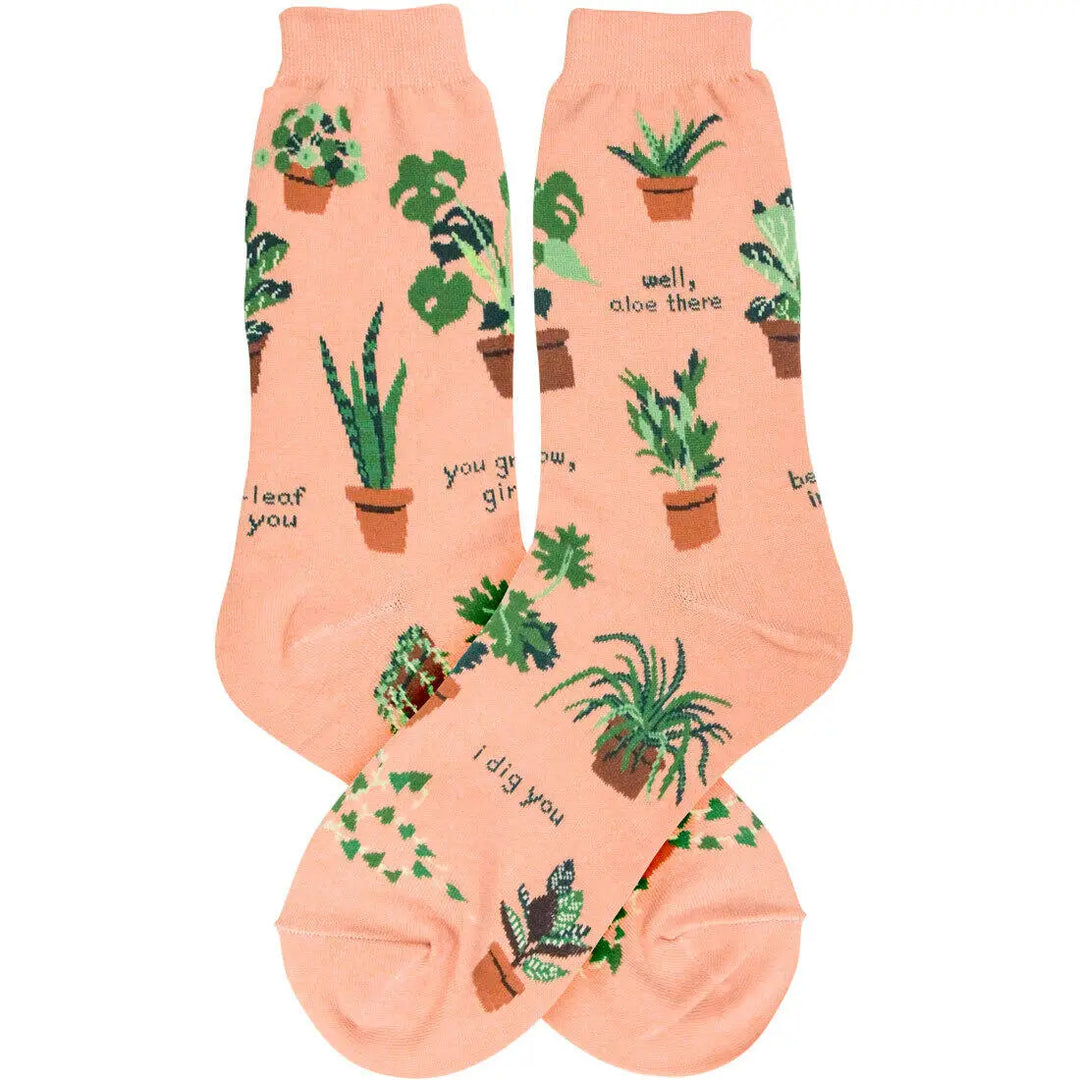 Peach women’s socks with illustrated potted plants and playful plant-themed sayings like “Well, aloe there” and “I dig you.”