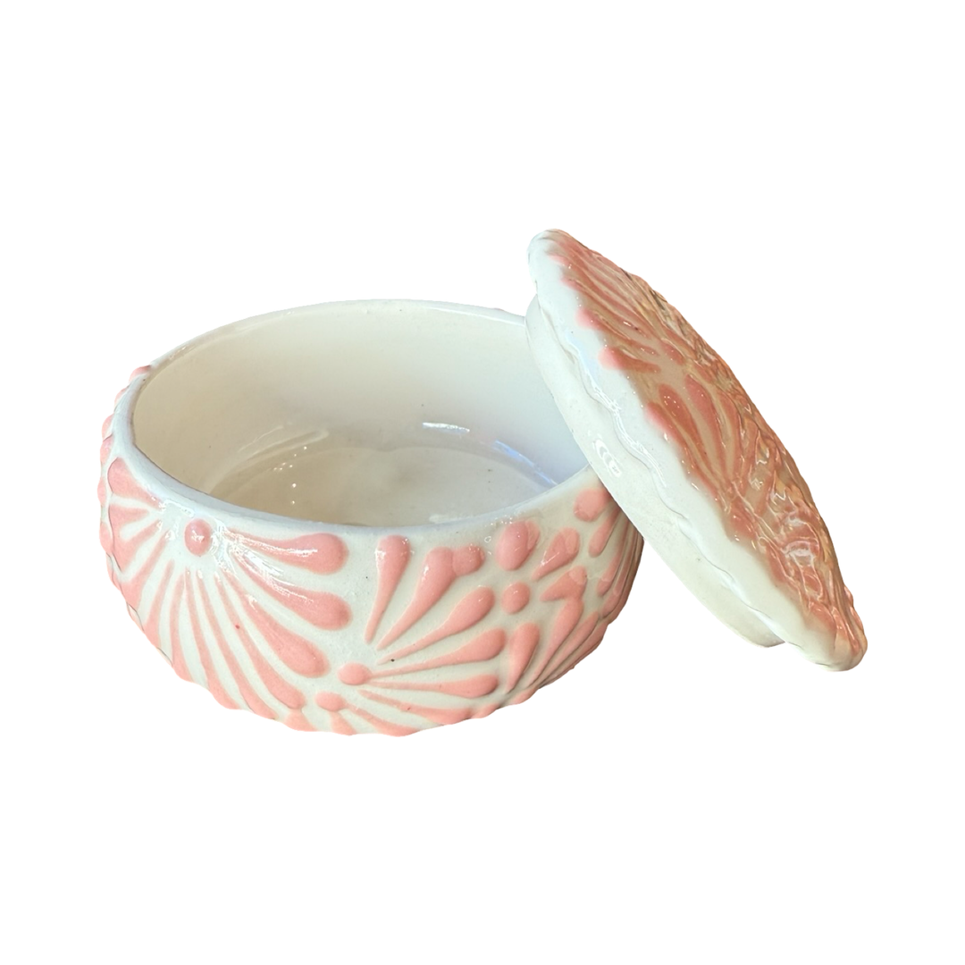 White ceramic lidded container with pink textured talavera design. Photo shows lid leaning against the right edge of the empty container.