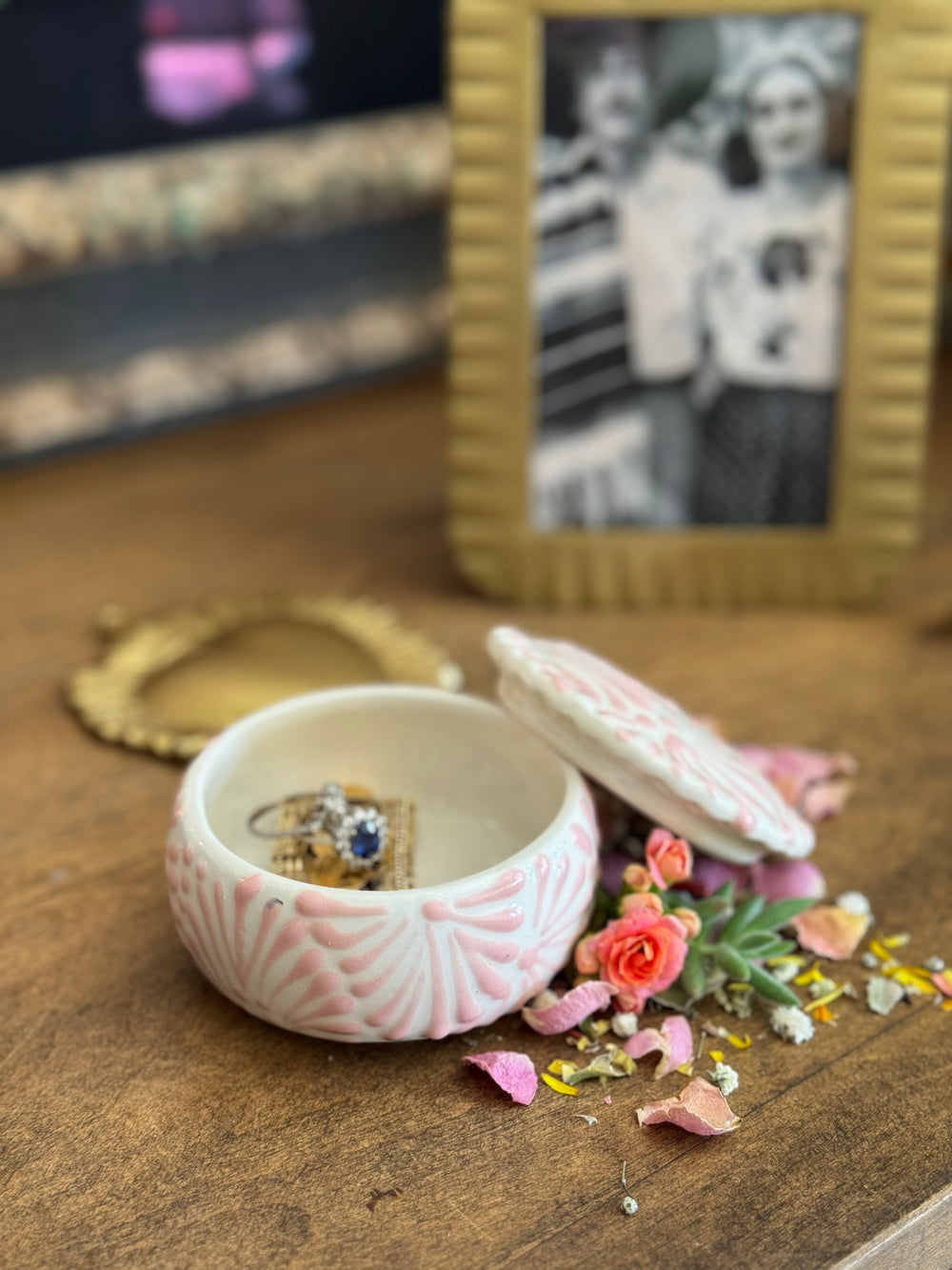 White ceramic lidded container with pink textured talavera design. Photo shows lid leaning against the right edge of the empty container.