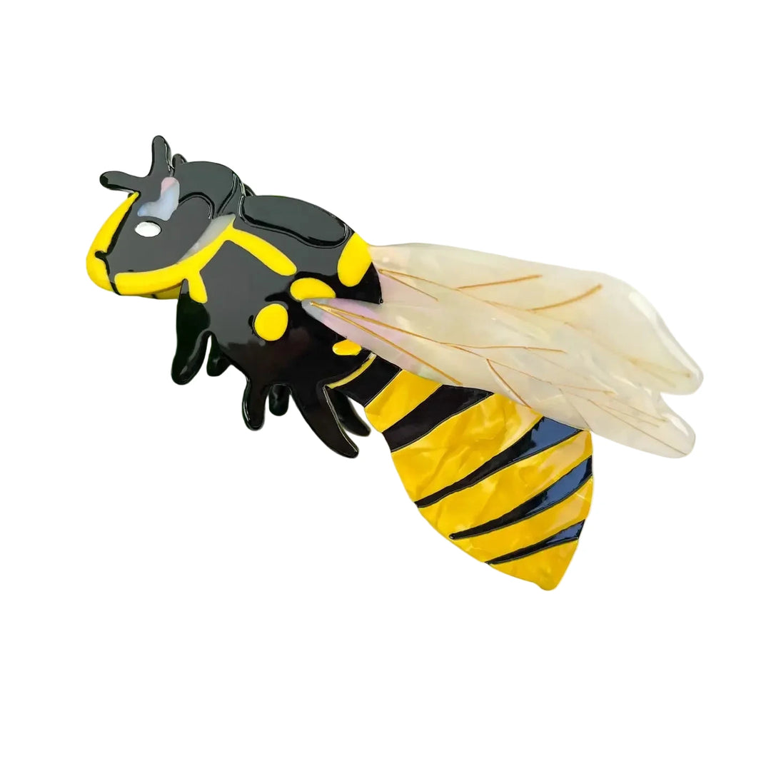 A decorative hair claw clip shaped like a bumblebee with a glossy black and yellow striped abdomen, black torso with yellow accents, tiny black legs and antennae, and translucent iridescent wings.