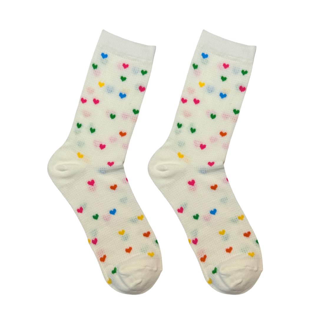 Pair of cream socks covered with tiny yellow, orange, pink, blue and green hearts.