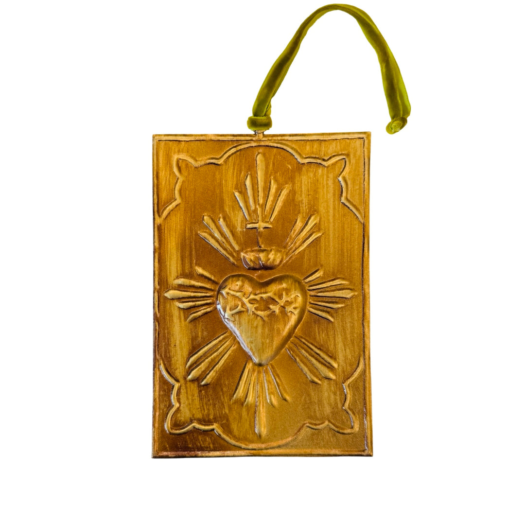 Gold rectangular ornament with embossed Sacred Heart design has a velvet green ribbon for hanging at the center top edge.