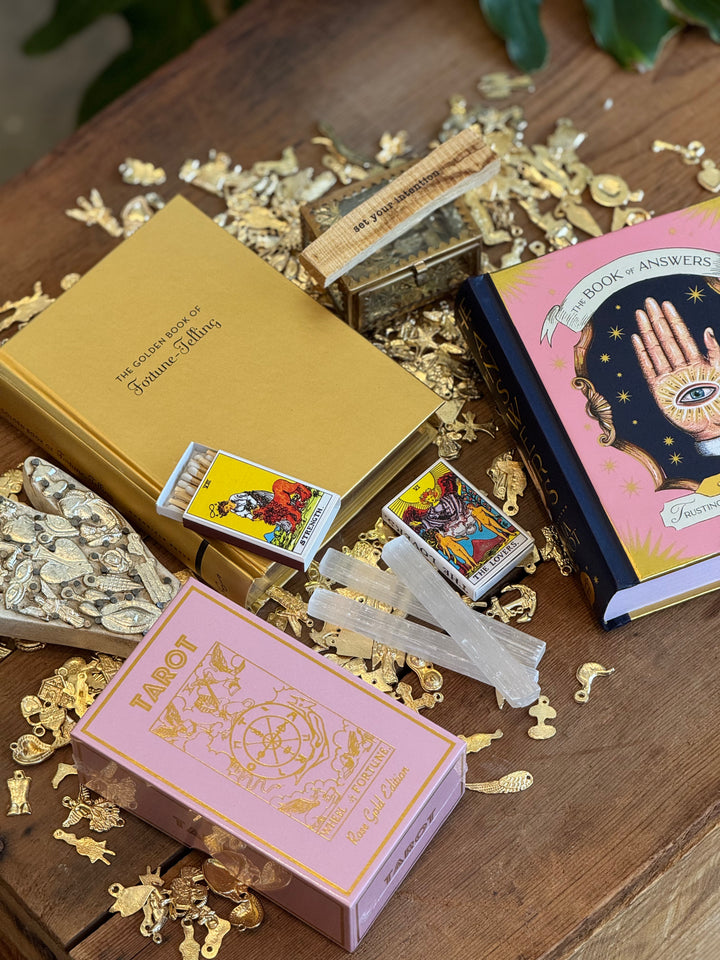 Alternate room view displays fortune telling themed books, tarot cards and accessories on a wooden surface.