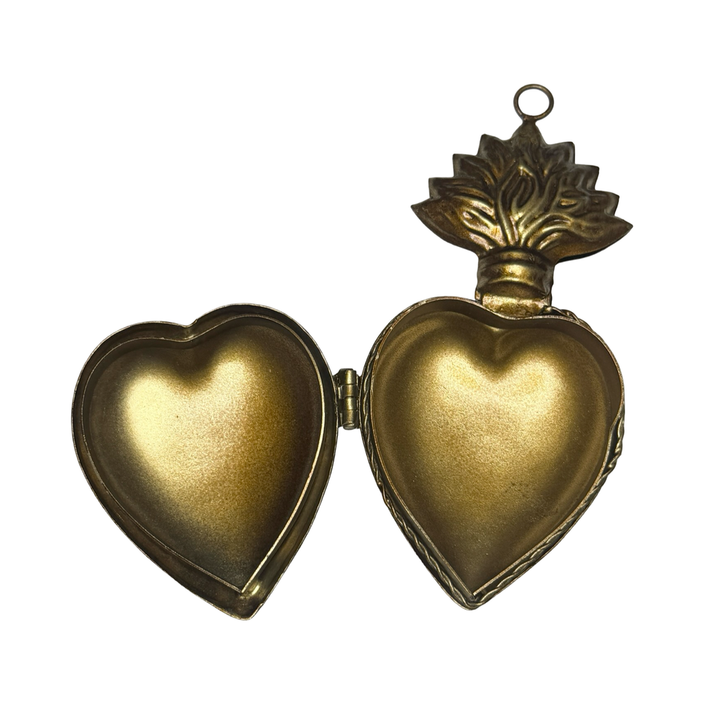 opened brass heart locket featuring an engraved design.