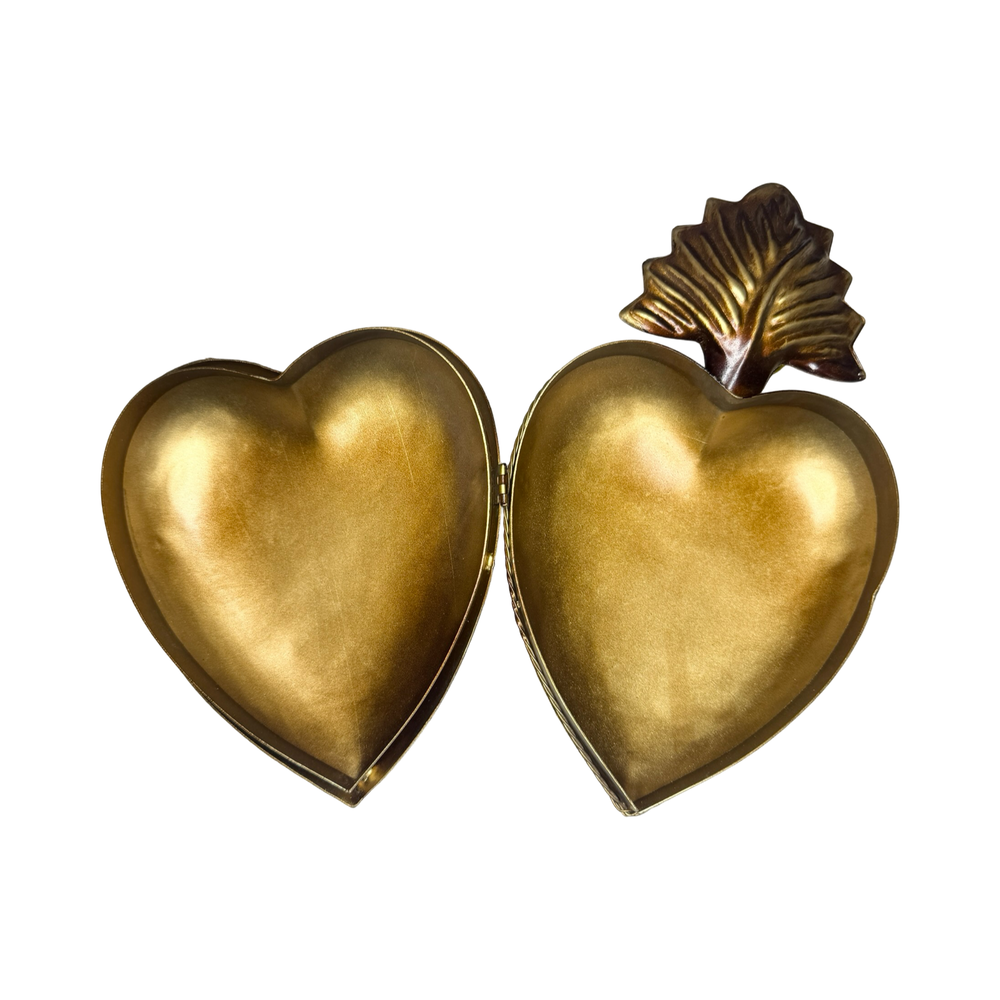 opened brass heart locket featuring an engraved design 