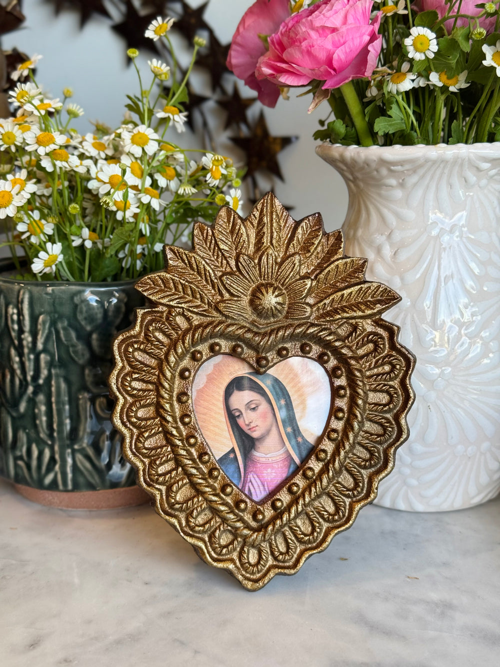 Decorative heart-shaped frame with a portrait in front of flowers and vases