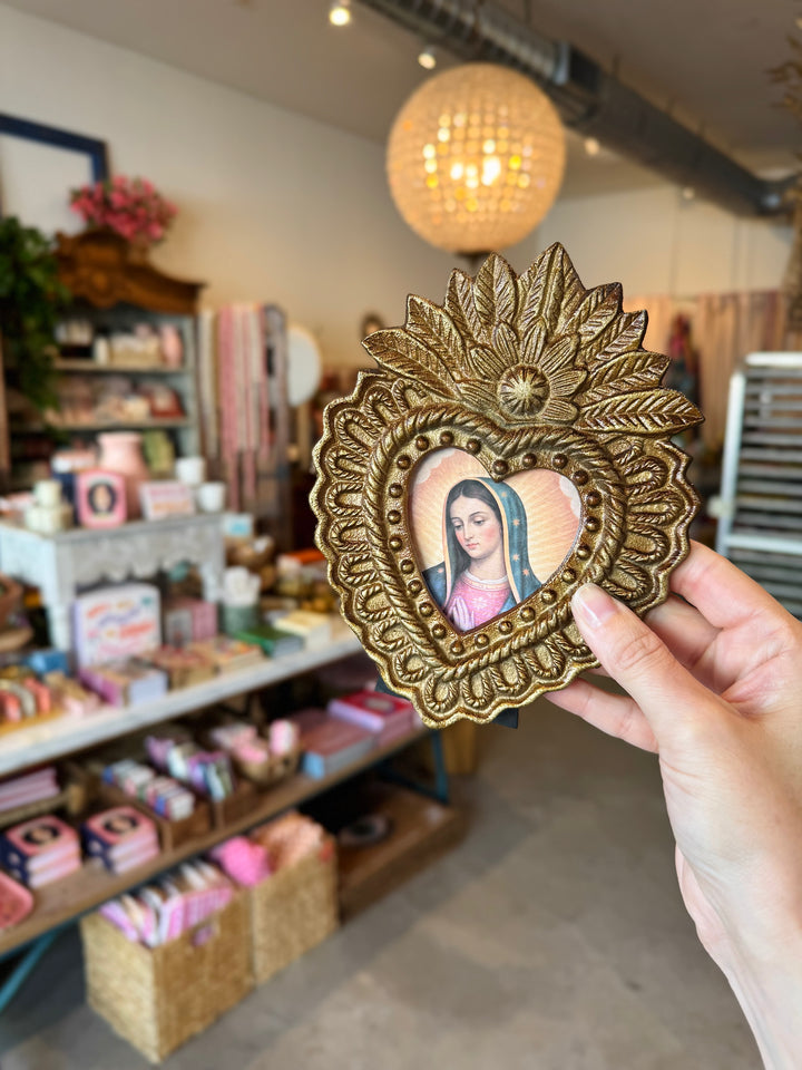 Decorative framed picture held by a hand in a store setting