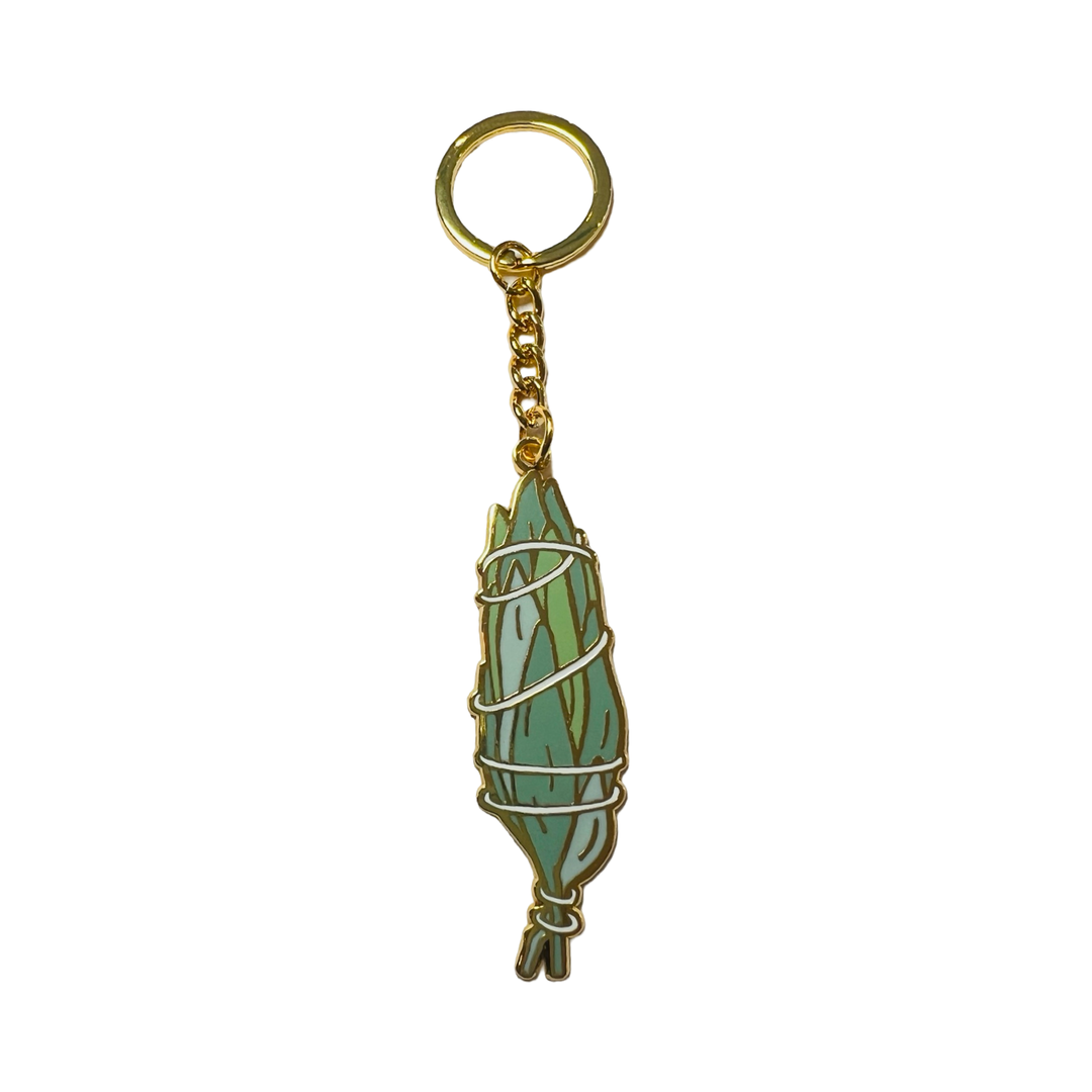 Sage bundle wrapped in white string keychain made with enamel and gold tone metal.