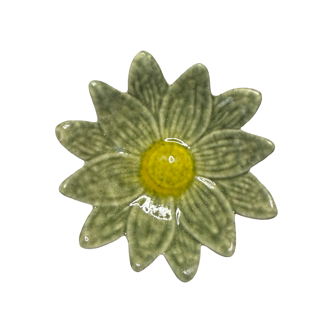 Stoneware daisy-shaped dish in sage green with a yellow center glaze