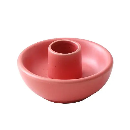 Round pink ceramic candle holder on a white background.