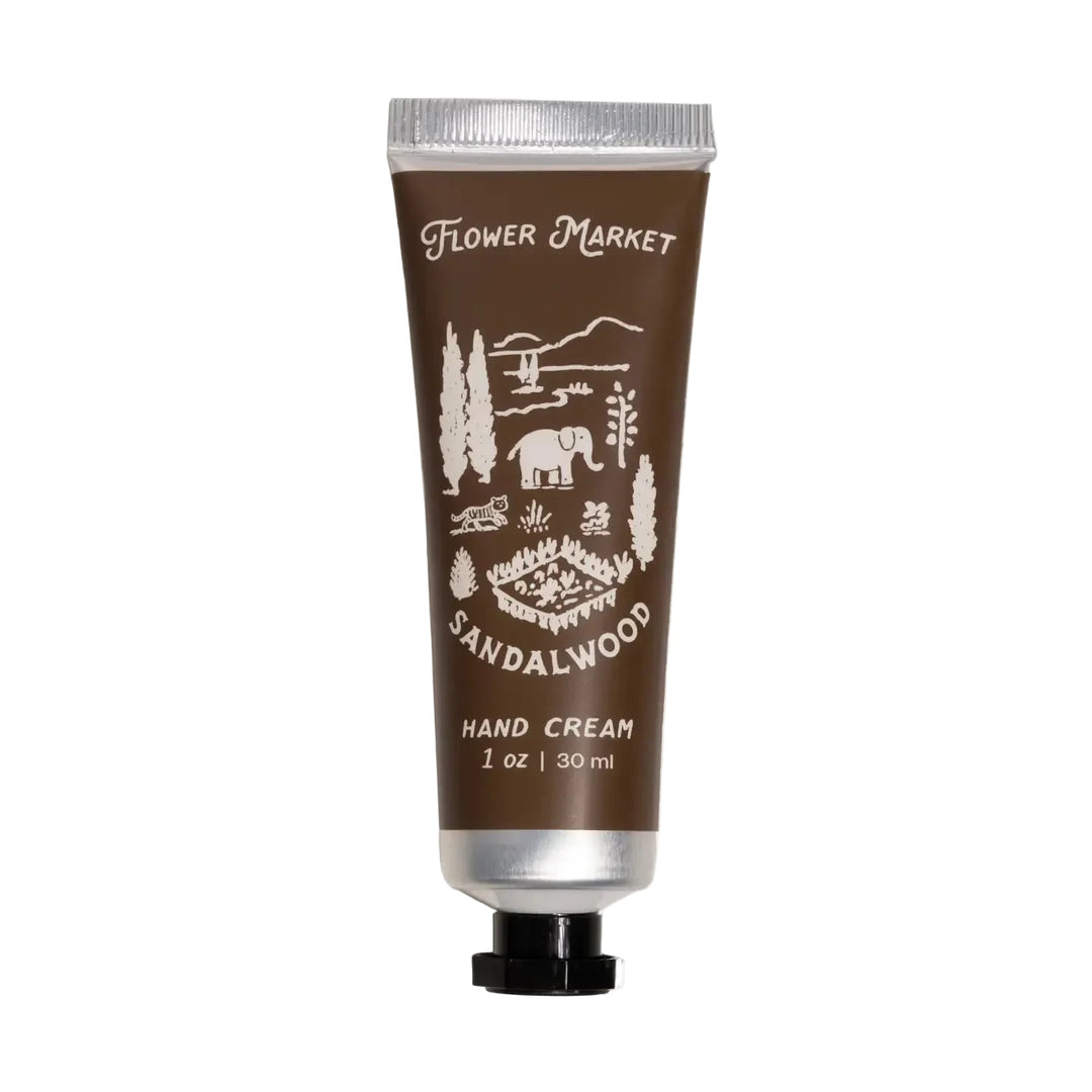 A 1 oz deep brown tube of Flower Market Sandalwood Hand Cream with a scenic illustration of elephants, tigers, and trees.