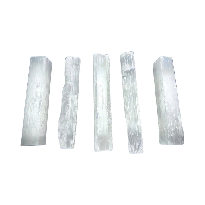 four selenite crystal wands lined up in a row