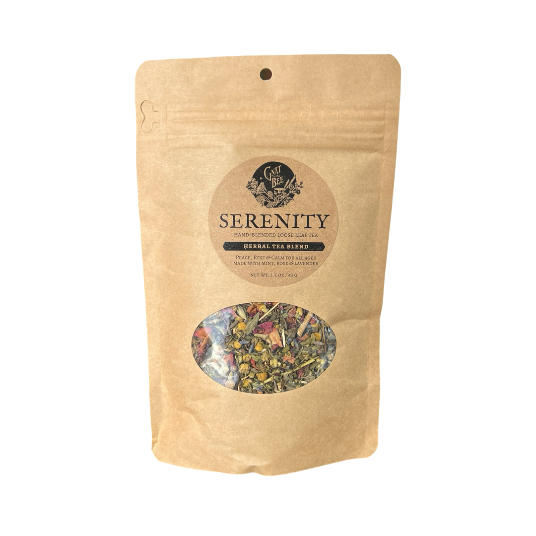 2 oz kraft pouch of Serenty tea with a branded label and a clear window that displays the dried herbs and flowers that makes the tea.