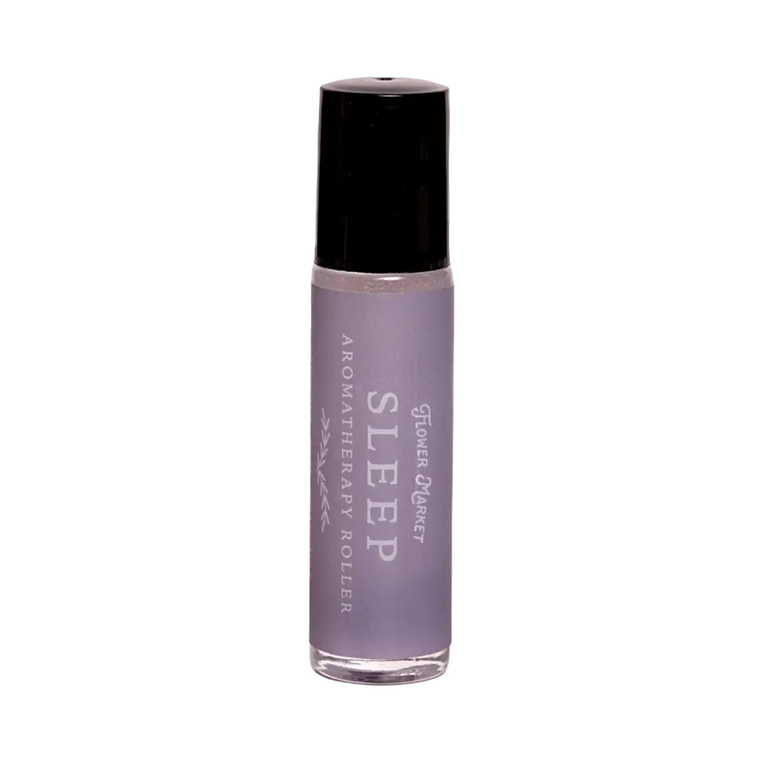 Small glass aromatherapy roller bottle with a lavender-toned label reading "Sleep Aromatherapy Roller" by Flower Market.