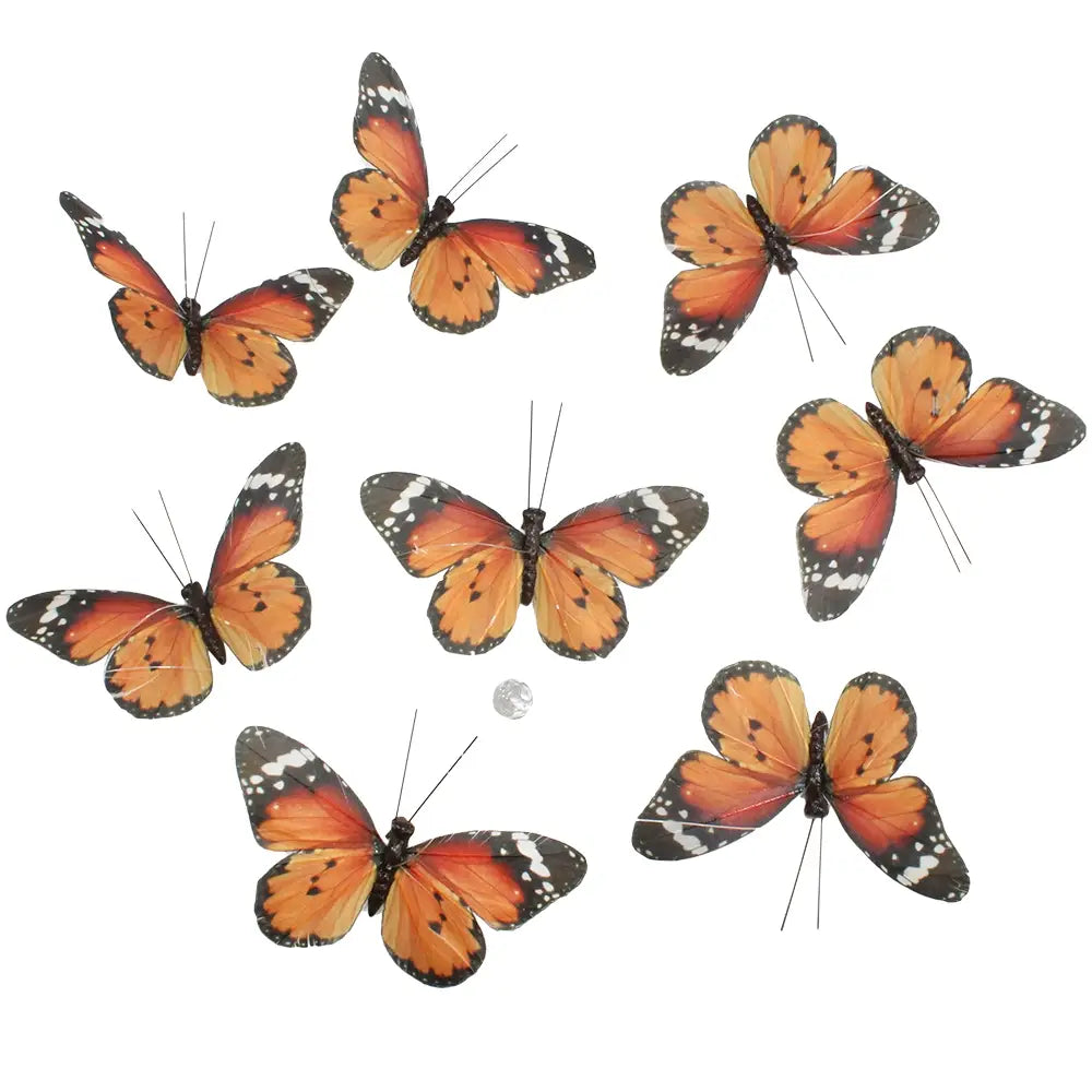 et of eight small artificial monarch butterflies with feather wings and wire antennae, arranged around a small clear bead.
