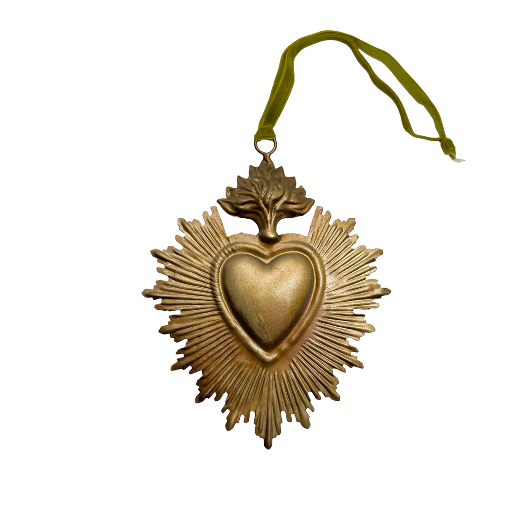 brass sacred heart with rays and a green ribbon to hang it from.