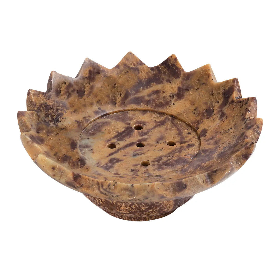 Brown marbled soapstone soap dish carved in a flower shape with pointed petal edges and drainage holes in the center.