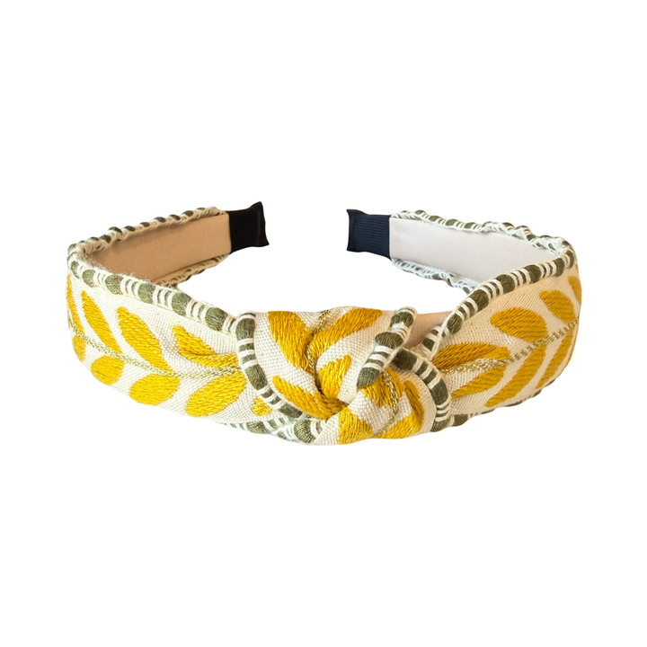 top view of a Slim embroidered headband with yellow leaf pattern and green trim on structured band.