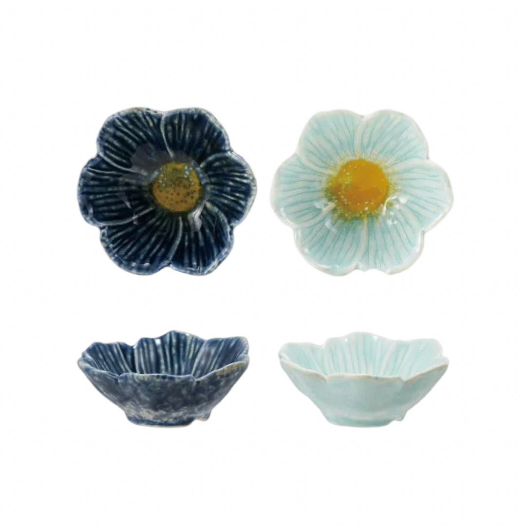 Two stoneware flower-shaped bowls shown from top and side view, in navy blue and mint, each with a yellow center glaze.
