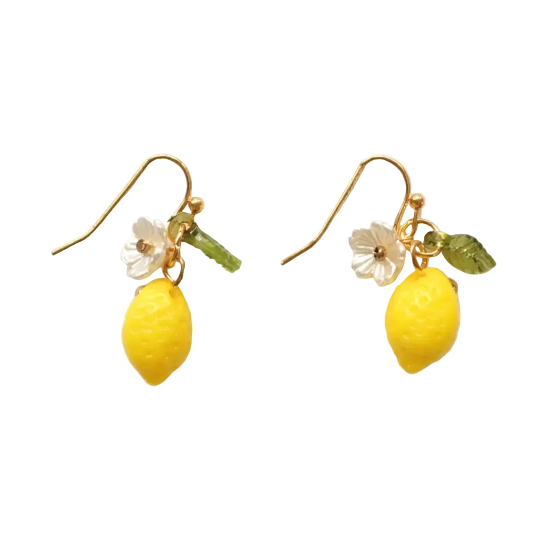 A pair of gold-tone fish hook earrings each featuring a bright yellow textured lemon charm, a small white flower blossom, and a faceted green leaf crystal.