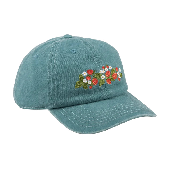A washed teal baseball cap with an embroidered strawberry and daisy botanical design on the front panel.
