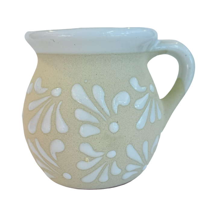 white mug with a white glazed design and a white rim