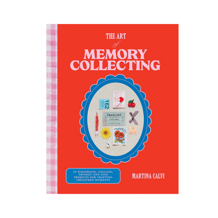 Book titled 'The Art of Memory Collecting' features a red cover with pink and white gingham spine. A bright blue oval frame sits in the middle covered with small momentos like ticket stubs, a ribbon and a dried flower. The book title text is in light pink at the top of the page and the author is listed in the bottom right hand corner.