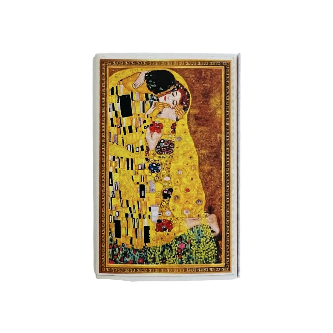 A matchbox featuring Gustav Klimt's "The Kiss" painting on the cover. The artwork showcases a romantic embrace in golden hues with intricate patterns, set against a rich background.