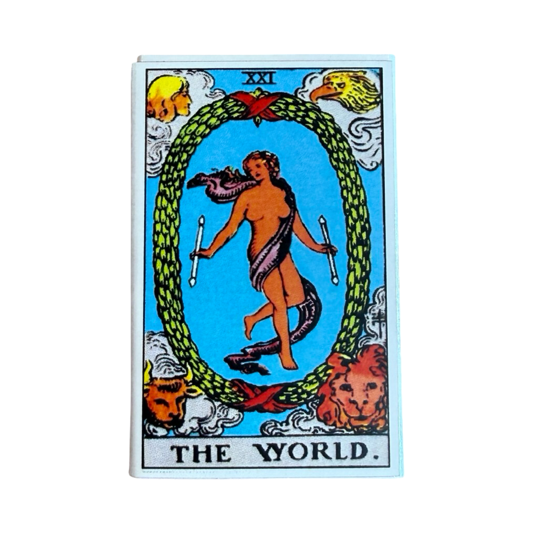 Match box featuring the tarot card “The World” with a central figure inside a green wreath surrounded by symbolic figures in the corners.
