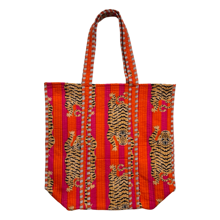A vibrant quilted tote bag featuring an orange and black tiger print on a pink and orange striped background. The bag has two sturdy quilted handles with a matching striped pattern