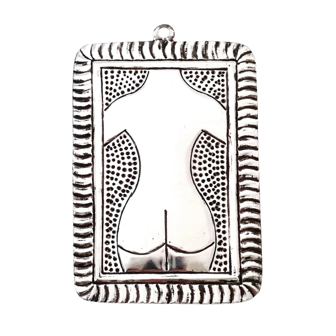 Tin plaque with a hammered image of a nude backside of a female.
