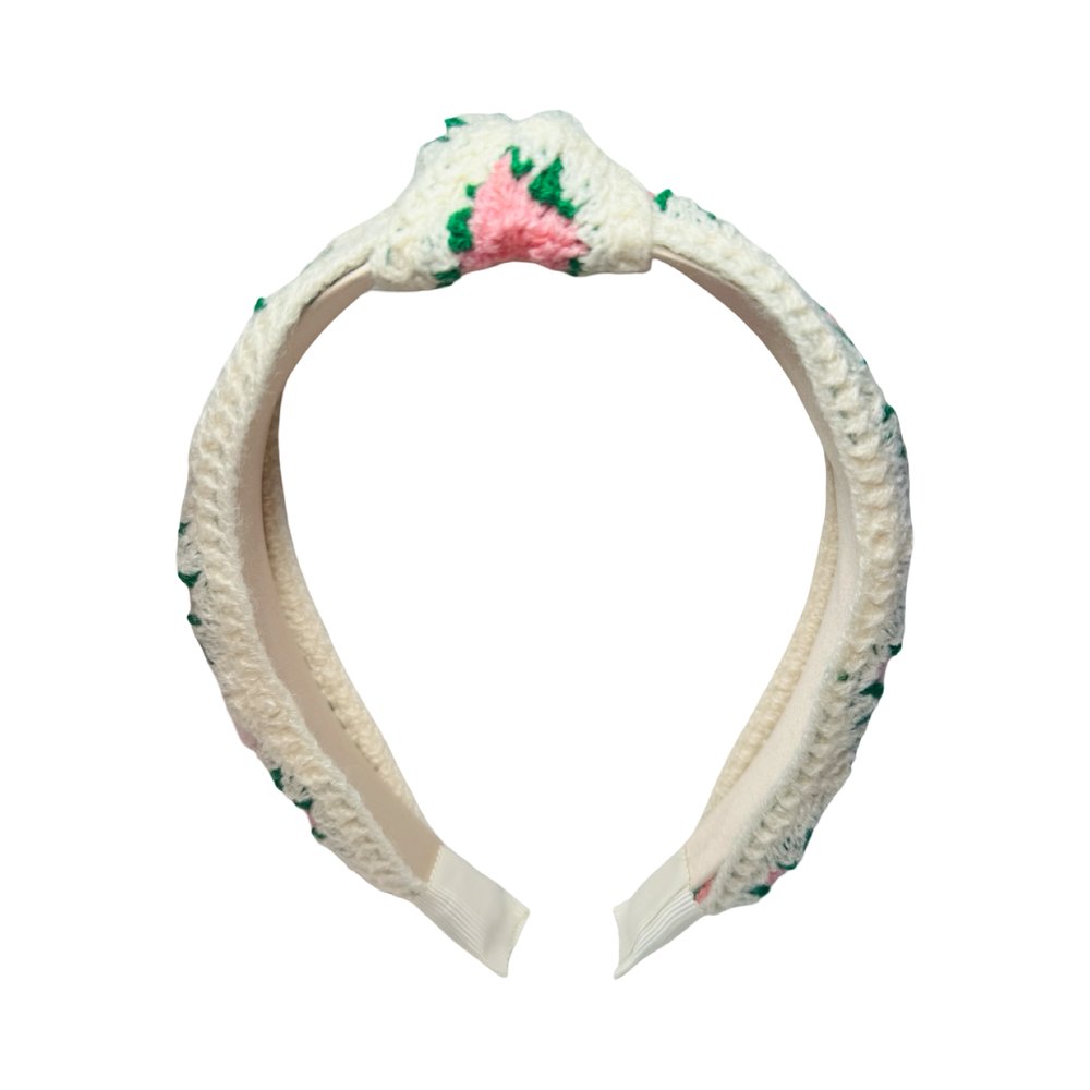 Front view of a cream crochet headband with pink and coral floral patterns and a knotted top design.
