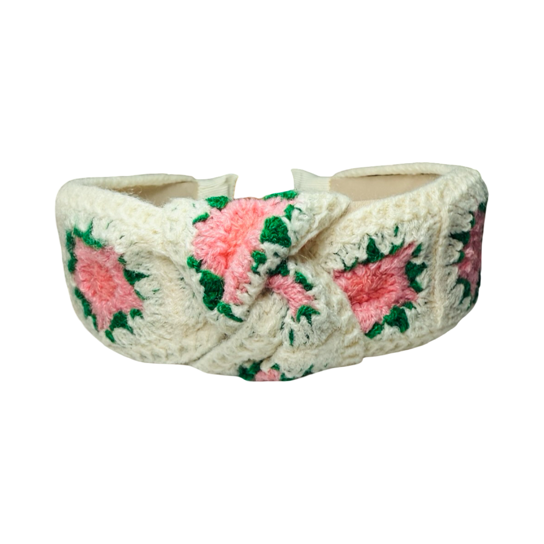 Top view of a cream crochet headband with pink and coral floral patterns and a knotted top design.