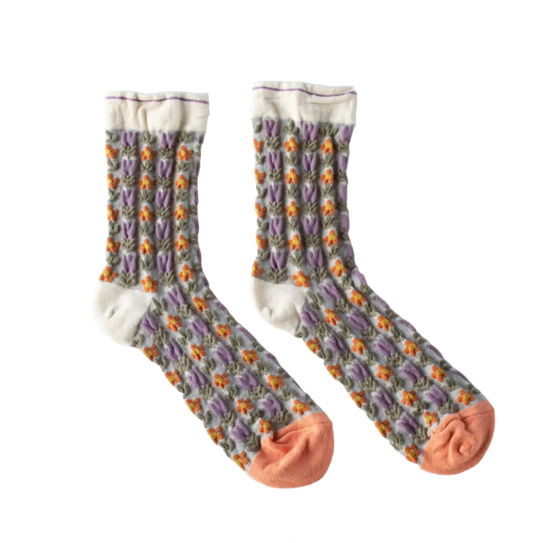 Pair of cream socks with lavender and orange floral pattern, peach toes, and vintage-inspired design.