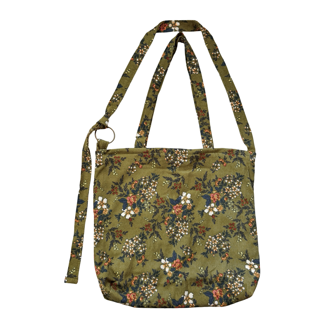 forest green corduroy tote bag with a pink and white flower design and long straps.