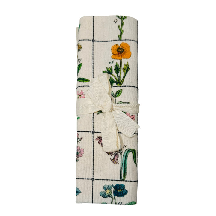 Organic cotton tea towel with illustrated wildflower chart folded in quarters.