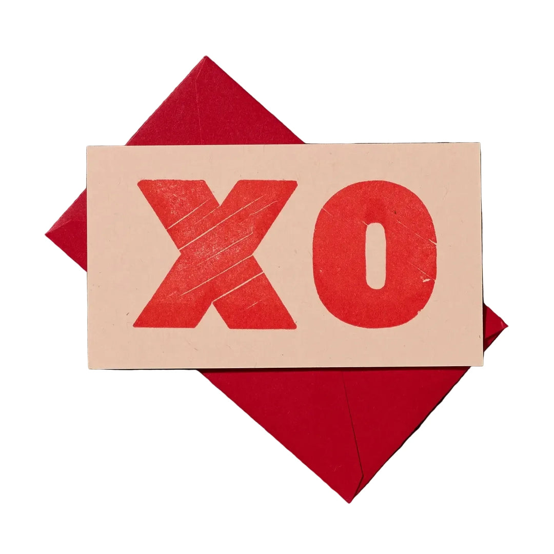 Mini greeting card with the letters “XO” printed in red lettering.