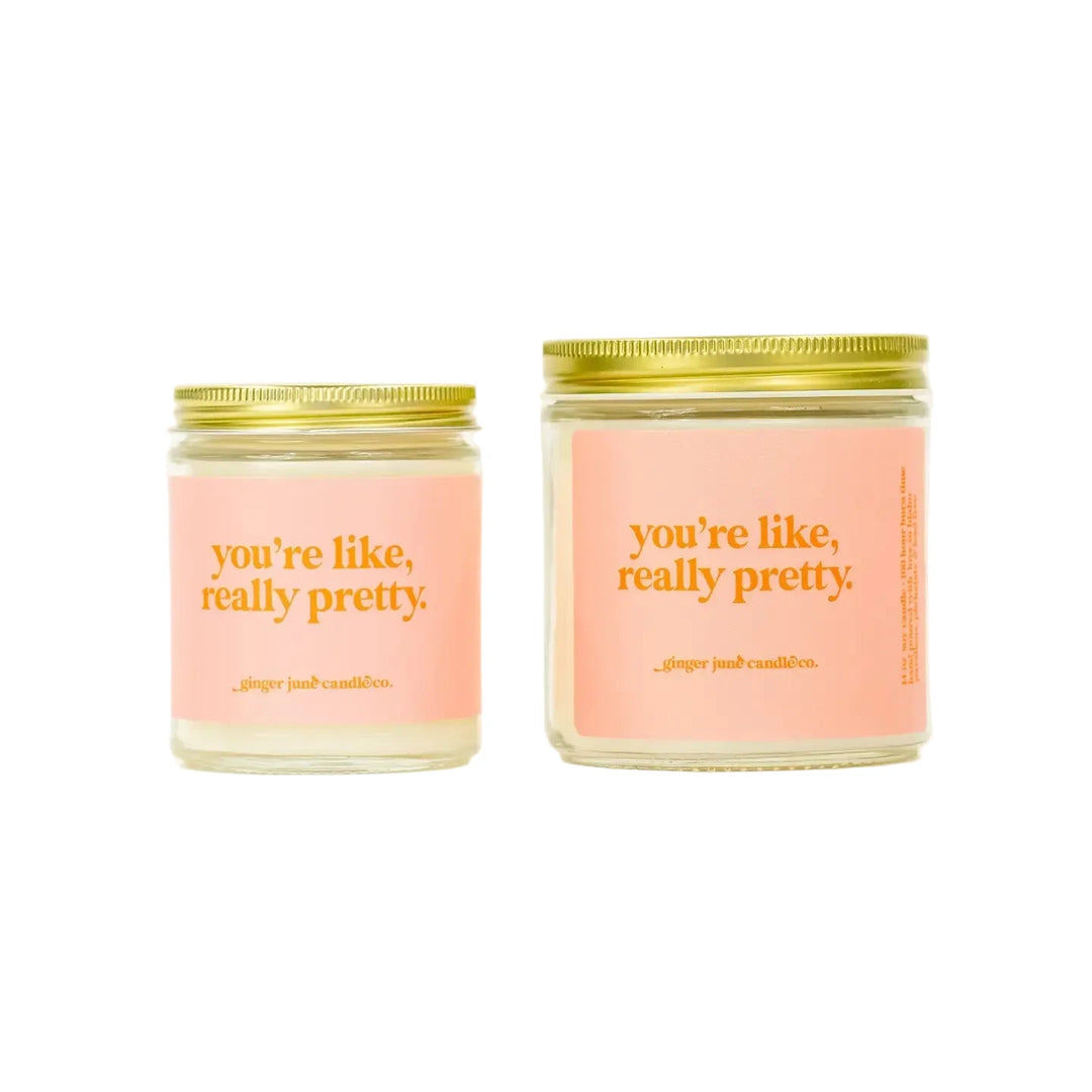 Two soy candles in glass jars with gold lids, each labeled “you’re like, really pretty.”