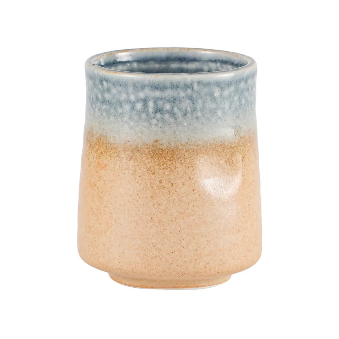 Small stoneware yunomi cup with sandy tan body and speckled blue rimmed glaze on a short footed base.