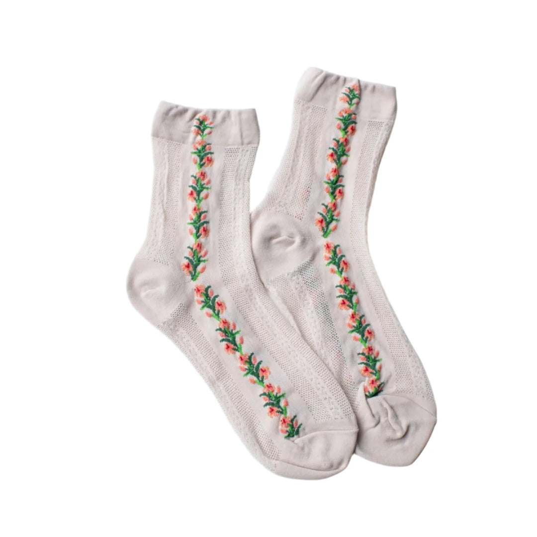 A pair of cream mesh socks with embroidered pink flowers and green leaves in a vertical pattern