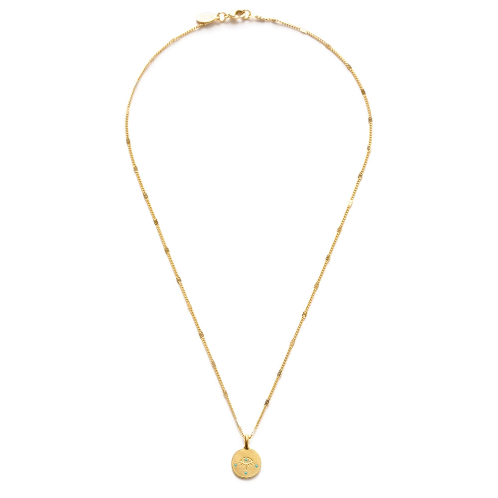 A small round gold coin pendant featuring an engraved evil eye with turquoise enamel dot accents, hung on a delicate mixed gold chain with flat bar and curb link details.